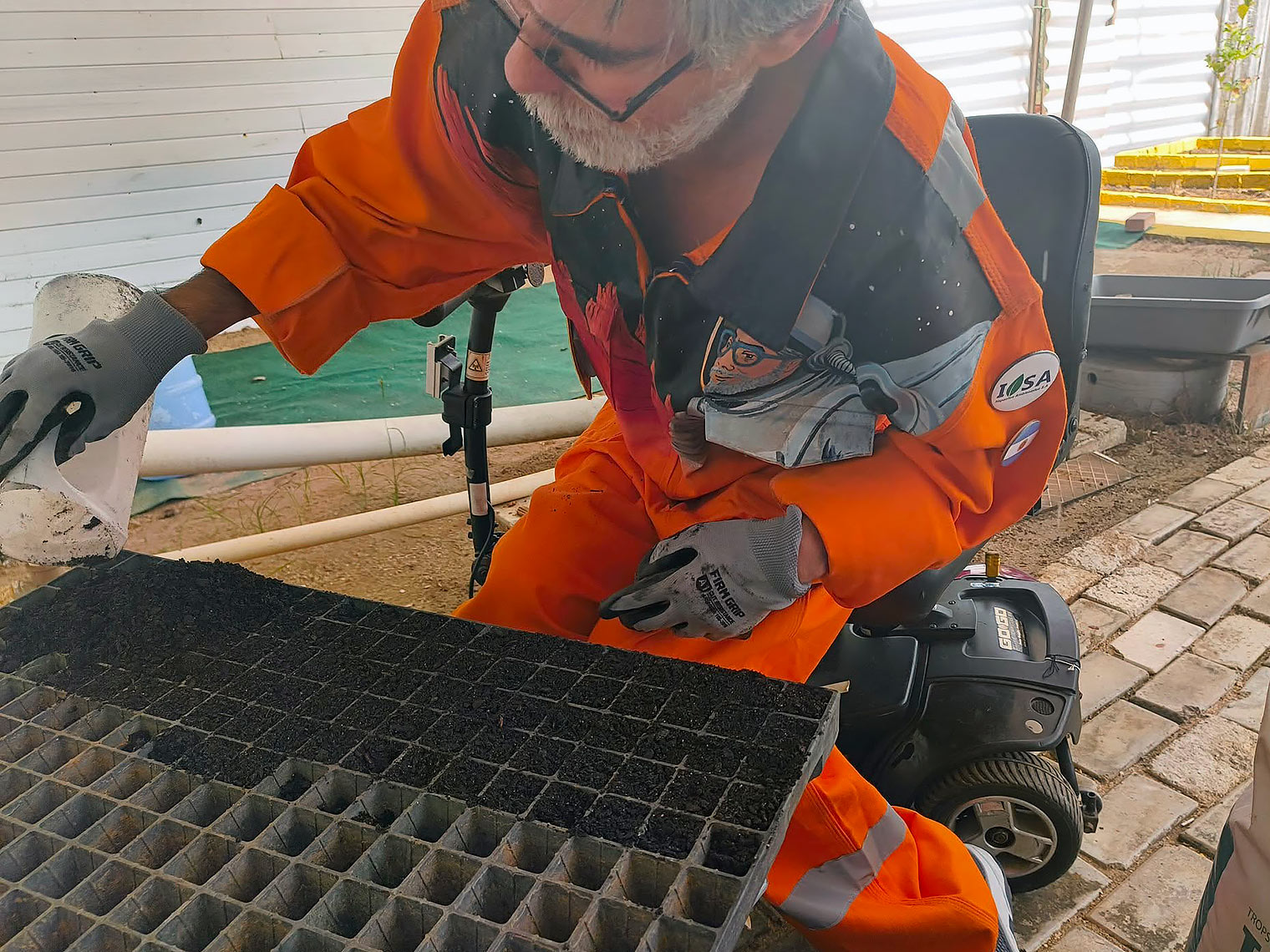 Sebastián Musso trabajando con muestras de polvo oscuro grnular en una cuadrícula.